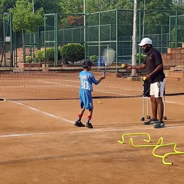 Delhi, Hindistan, 17 Şubat 2025 - Maha Open için kil tenis kortunda antrenörlük yapan genç tenisçiler, yaklaşan turnuva için küçük tenis oyuncuları antrenman yapıyor
