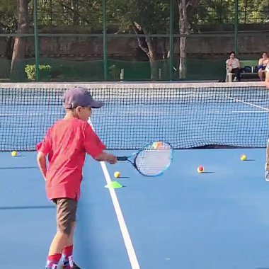 Delhi, Hindistan, 17 Şubat 2025 - Maha Open için kil tenis kortunda antrenörlük yapan genç tenisçiler, yaklaşan turnuva için küçük tenis oyuncuları antrenman yapıyor