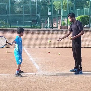 Delhi, Hindistan, 17 Şubat 2025 - Maha Open için kil tenis kortunda antrenörlük yapan genç tenisçiler, yaklaşan turnuva için küçük tenis oyuncuları antrenman yapıyor