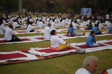 Yeni Delhi, Hindistan, 21 Haziran 2025 - Uluslararası Yoga Günü 'nde Delhi' deki Yamuna Spor Kompleksi 'nde grup Yoga egzersiz oturumu, kriket stadyumunda yoga sınıfına katılan büyük bir grup yetişkin