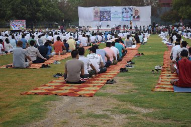 Yeni Delhi, Hindistan, 21 Haziran 2025 - Uluslararası Yoga Günü 'nde Delhi' deki Yamuna Spor Kompleksi 'nde grup Yoga egzersiz oturumu, kriket stadyumunda yoga sınıfına katılan büyük bir grup yetişkin
