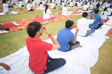 Yeni Delhi, Hindistan, 21 Haziran 2025 - Uluslararası Yoga Günü 'nde Delhi' deki Yamuna Spor Kompleksi 'nde grup Yoga egzersiz oturumu, kriket stadyumunda yoga sınıfına katılan büyük bir grup yetişkin