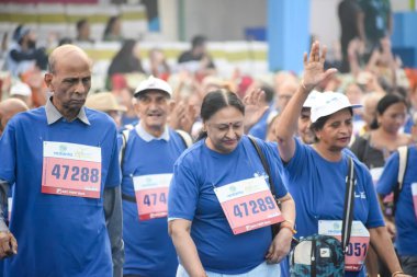 Yeni Delhi, Hindistan - 20 Ekim 2024 - Vedanta Delhi Yarı Maraton yarışına katılan yaşlılar maraton katılımcılarının bitiş çizgisini geçmek üzere oldukları Delhi Yarı Maratonu 2024