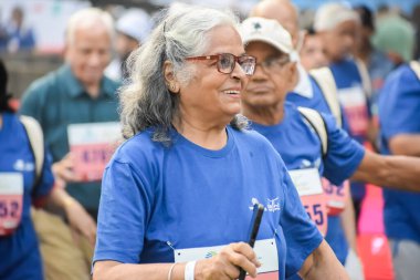 Yeni Delhi, Hindistan - 20 Ekim 2024 - Vedanta Delhi Yarı Maraton yarışına katılan yaşlılar maraton katılımcılarının bitiş çizgisini geçmek üzere oldukları Delhi Yarı Maratonu 2024