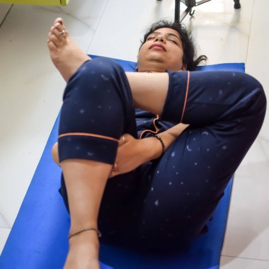 Evde yoga yapan genç Hintli bir kadın çevrimiçi yoga seansında güzel bir kız temel yoga pozisyonunda Asyalı bir kadın kapalı alanda yoga yapıyor.