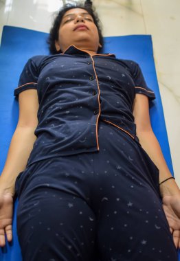 Evde yoga yapan genç Hintli bir kadın çevrimiçi yoga seansında güzel bir kız temel yoga pozisyonunda Asyalı bir kadın kapalı alanda yoga yapıyor.