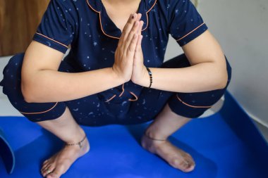 Evde yoga yapan genç Hintli bir kadın çevrimiçi yoga seansında güzel bir kız temel yoga pozisyonunda Asyalı bir kadın kapalı alanda yoga yapıyor.