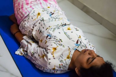 Evde yoga yapan genç Hintli bir kadın çevrimiçi yoga seansında güzel bir kız temel yoga pozisyonunda Asyalı bir kadın kapalı alanda yoga yapıyor.