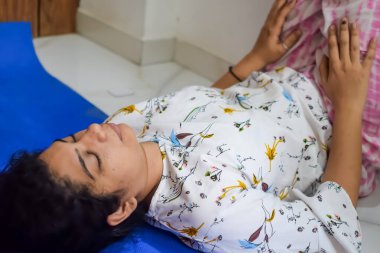 Evde yoga yapan genç Hintli bir kadın çevrimiçi yoga seansında güzel bir kız temel yoga pozisyonunda Asyalı bir kadın kapalı alanda yoga yapıyor.