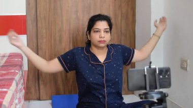 Evde yoga yapan genç Hintli bir kadın çevrimiçi yoga seansında güzel bir kız temel yoga pozisyonunda Asyalı bir kadın kapalı alanda yoga yapıyor. 