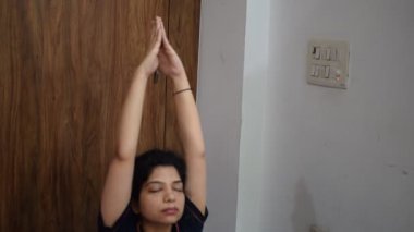Evde yoga yapan genç Hintli bir kadın çevrimiçi yoga seansında güzel bir kız temel yoga pozisyonunda Asyalı bir kadın kapalı alanda yoga yapıyor. 
