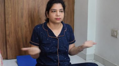 Evde yoga yapan genç Hintli bir kadın çevrimiçi yoga seansında güzel bir kız temel yoga pozisyonunda Asyalı bir kadın kapalı alanda yoga yapıyor. 