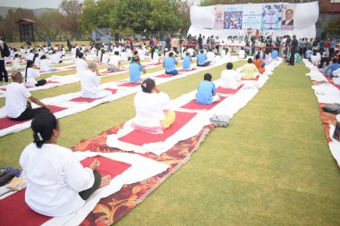 Yeni Delhi, Hindistan, 21 Haziran 2025 - Uluslararası Yoga Günü 'nde Delhi' deki Yamuna Spor Kompleksi 'nde grup Yoga egzersiz oturumu, kriket stadyumunda yoga sınıfına katılan büyük bir grup yetişkin