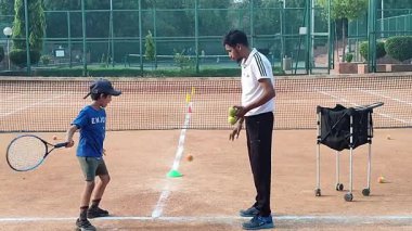 Delhi, Hindistan, 17 Şubat 2025 - Maha Open için kil tenis kortunda antrenörlük yapan genç tenisçiler, yaklaşan turnuva için küçük tenis oyuncuları antrenman yapıyor