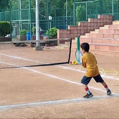 Delhi, Hindistan, 17 Şubat 2025 - Maha Open için kil tenis kortunda antrenörlük yapan genç tenisçiler, yaklaşan turnuva için küçük tenis oyuncuları antrenman yapıyor
