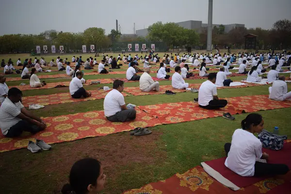 Yeni Delhi, Hindistan, 21 Haziran 2025 - Uluslararası Yoga Günü 'nde Delhi' deki Yamuna Spor Kompleksi 'nde grup Yoga egzersiz oturumu, kriket stadyumunda yoga sınıfına katılan büyük bir grup yetişkin