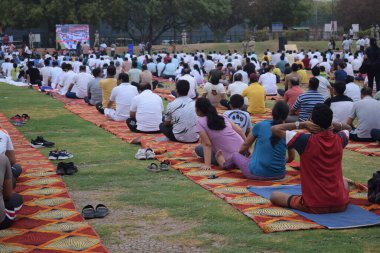 Yeni Delhi, Hindistan, 21 Haziran 2025 - Uluslararası Yoga Günü 'nde Delhi' deki Yamuna Spor Kompleksi 'nde grup Yoga egzersiz oturumu, kriket stadyumunda yoga sınıfına katılan büyük bir grup yetişkin