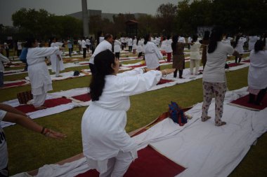 Yeni Delhi, Hindistan, 21 Haziran 2025 - Uluslararası Yoga Günü 'nde Delhi' deki Yamuna Spor Kompleksi 'nde grup Yoga egzersiz oturumu, kriket stadyumunda yoga sınıfına katılan büyük bir grup yetişkin
