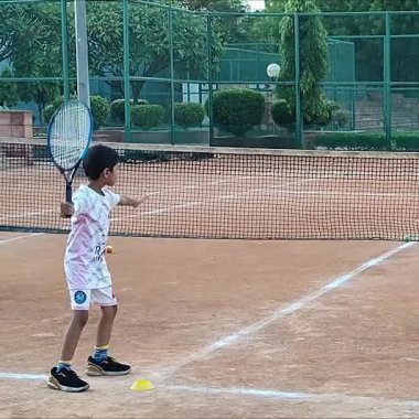 Delhi, Hindistan, 17 Şubat 2025 - Maha Open için kil tenis kortunda antrenörlük yapan genç tenisçiler, yaklaşan turnuva için küçük tenis oyuncuları antrenman yapıyor