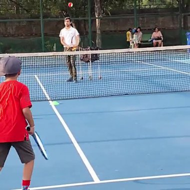 Delhi, Hindistan, 17 Şubat 2025 - Maha Open için kil tenis kortunda antrenörlük yapan genç tenisçiler, yaklaşan turnuva için küçük tenis oyuncuları antrenman yapıyor
