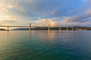 Beautiful modern bridge over the sea on Peljesac in Croatia. In the foreground houses and in the background the Peljesac mountain