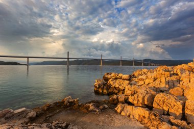 Beautiful modern bridge over the sea on Peljesac in Croatia. In the foreground houses and in the background the Peljesac mountain