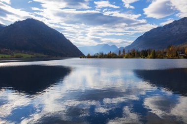 Grundlsee Gölü, arka planda yükselen dağlarla gölün sakin yüzeyine bak..