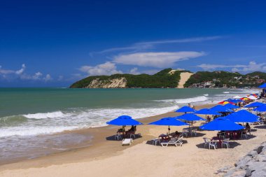 Ponta Negra plajı, arka planda renkli şemsiyeler ve Morro do Careca, Natal, Rio Grande do Norte, Brezilya, 22 Mart 2024.