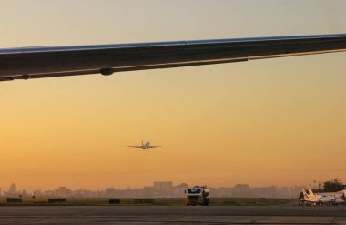 Airplane taking off in the late afternoon with sunset light at Congonhas Airport, Sao Paulo, SP, Brazil on April 1, 2005. clipart