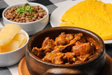 Brezilya kuskusu ile kızartılmış keçi, pilav, fasulye, kasava ve sirke ile çiftleştirilmiş siyah beyaz kareli masa örtüsünün üzerinde beyaz bir tabakta. Kuzeydoğu Brezilya mutfağı.