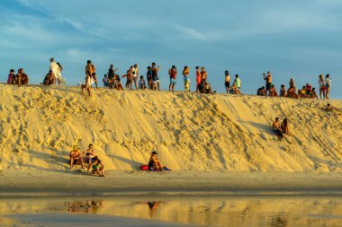 Jericoacoara plajı, Ceara eyaleti, Brezilya 23 Ocak 2023. Gün batımı kum tepesi. İnsanlar öğleden sonranın sonunu düşünüyor..