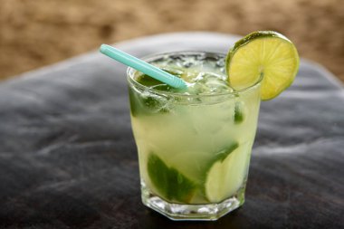 Brezilya Caipirinha içkisi kumlu plaj geçmişi olan ahşap bir masada..