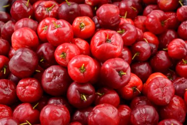 Fresh organic cherry acerolas close-up forming a background pattern. clipart