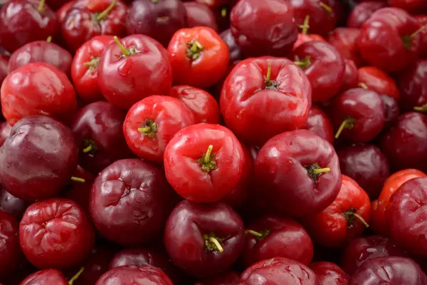 stock image Fresh organic cherry acerolas close-up forming a background pattern.