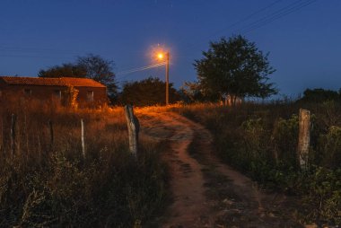 3 Ağustos 2011 'de Brezilya' nın Paraiba eyaletinin Sao Bento kentindeki Dusk kasabasında Sokak Işığı ile Kırsal Elektrik.
