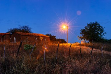 3 Ağustos 2011 'de Brezilya' nın Paraiba eyaletinin Sao Bento kentindeki Dusk kasabasında Sokak Işığı ile Kırsal Elektrik.