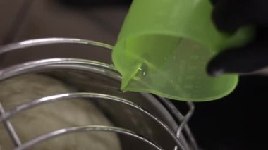 Senior professional chef kneading floured dough at bakery, mature retiree enjoying hobby making homemade bread using traditional recipe isolated on black background close up. High quality footage