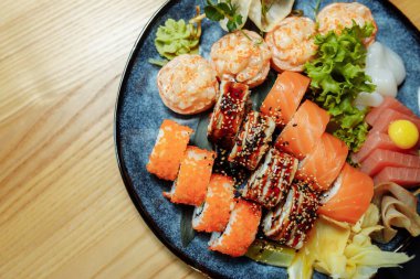 Karışık suşi seti nigiri, rulo ve sashimi geleneksel Japonya siyah suşi yuvarlak tabağında servis edilir. Yüksek kalite fotoğraf