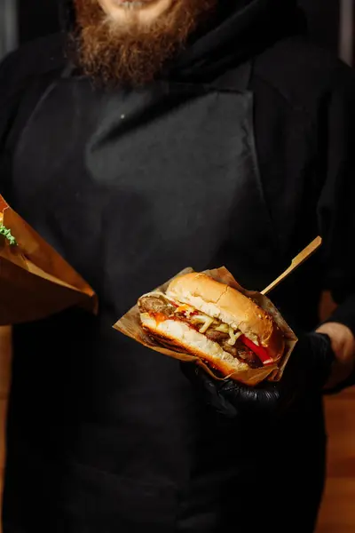 Man Black Gloves Holding Burger Hands Juicy Burger Close Appetizing burger. High quality photo