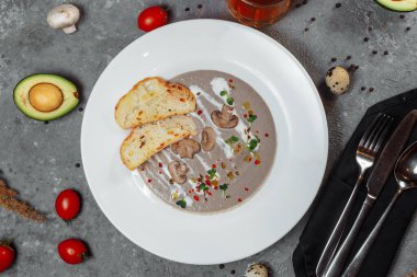 Mantar kremalı çorba ve gri arka plandaki malzemeler, kapatın. Yüksek kalite fotoğraf