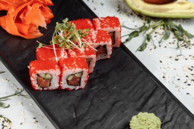 Geleneksel lezzetli suşi rulo seti. Pilavlı suşi, nori, krem peynir, tobiko havyarı, avokado. Suşi menüsü. Yüksek kalite fotoğraf