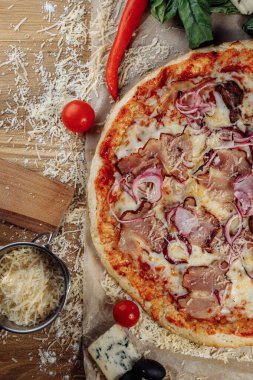 Tavuk peynirli ve pepperonili pizza, bir parçası pakman gibi kesilmiş ve serilmiş, ahşap bir tahtanın üzerinde ve kahverengi bir arka planda. Peynir akış çizgilerini yayar. Yüksek kalite fotoğraf