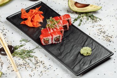 Geleneksel lezzetli suşi rulo seti. Pilavlı suşi, nori, krem peynir, tobiko havyarı, avokado. Suşi menüsü. Yüksek kalite fotoğraf