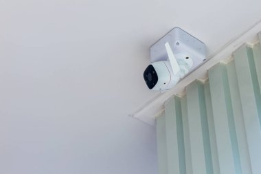 İç duvarda kablosuz kablosuz bağlantı kullanan modern beyaz CCTV kamerası