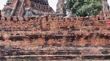 Geleneksel kırmızı Tayland elbisesi ve altın aksesuarlar giyen genç bir kadın Wat Chaiwatthanaram tapınağında geleneksel bir şemsiye taşıyor. Tayland ulusal kostümü