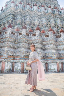 Wat Arun Ratchawararam 'da aksesuarlı Tayland elbisesi giyen genç bir kadın dünya turistleri için popüler bir yerdir. Bangkok, Tayland