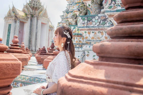 身穿传统泰式服装的年轻女子站在世界各国游客喜爱的旅游胜地Wat Arun 泰国曼谷 — 图库照片
