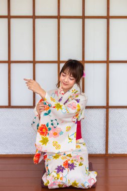 Japon tarzı ahşap evde geleneksel kimono giyen genç bir kadın.