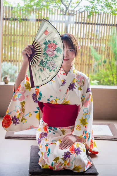 Jovem Mulher Vestindo Quimono Tradicional Japonês Segurando Ventilador Papel Sentado — Fotografia de Stock
