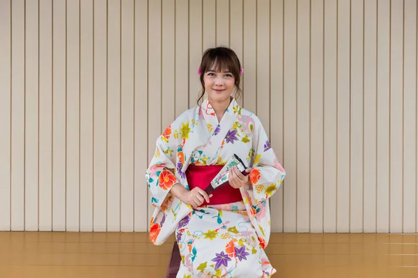 Mladá Žena Nosí Tradiční Japonské Kimono Drží Papírový Ventilátor Sedí — Stock fotografie